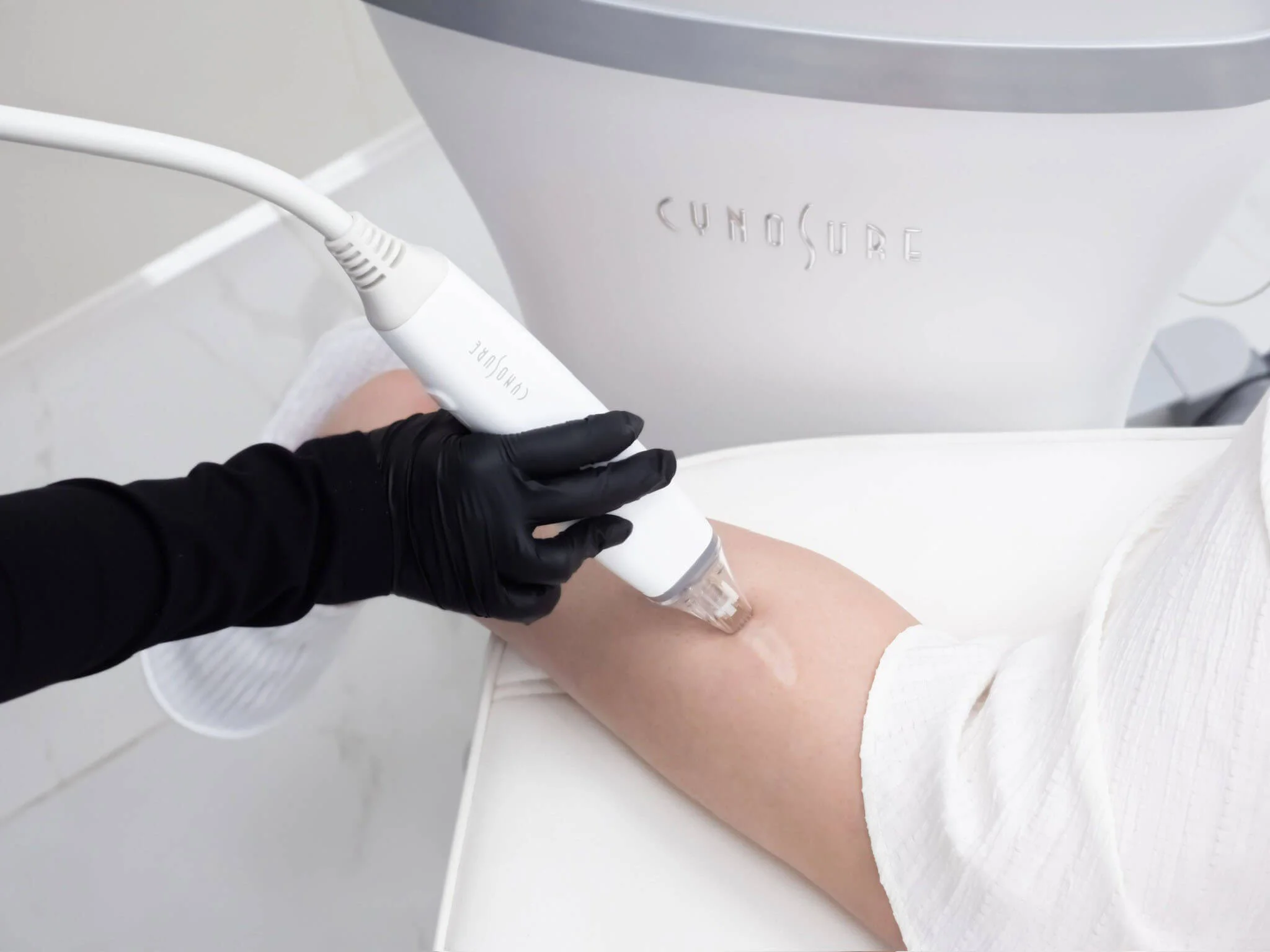 Treatment handpiece applied to a person’s abdomen with gloved hands